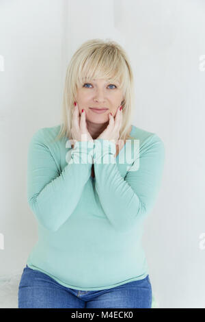 Blond woman with blue eyes in white Stock Photo - Alamy
