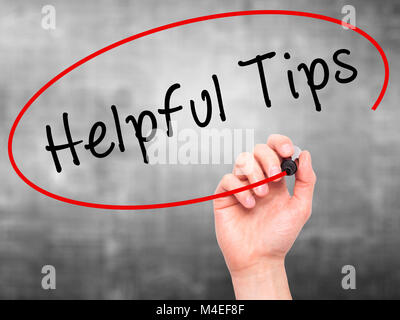 Man hand writing Helpful Tips on visual screen Stock Photo