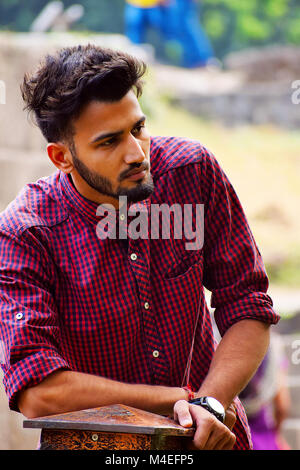 Young man with checked shirt thinking, Pune, Maharashtra. Stock Photo