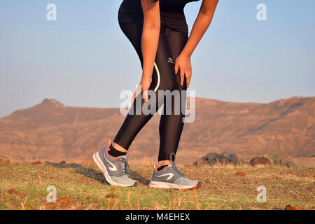 Close-up view of young girl with muscle cramp on leg while exercising, Pune, Maharashtra. Stock Photo