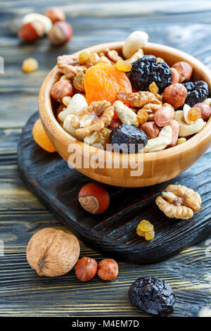 Dried fruit and mixed nuts in a wooden bowl. Stock Photo