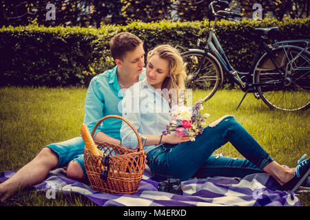 Lovely couple on picnik in a park in summer sunny day. Stock Photo