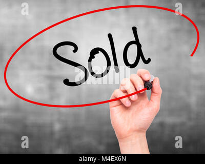 Man Hand writing Sold with black marker on visual screen Stock Photo