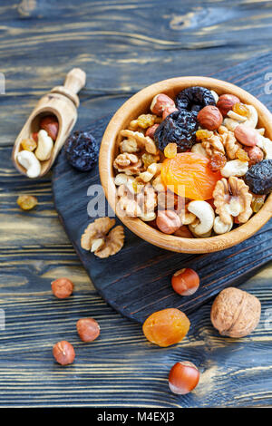 Mixture of nuts and dried fruit in a wooden bowl. Stock Photo