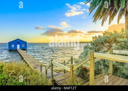 The iconic landscape of blue boat house from 1930s with wooden jetty on Swan River at sunset light. One of the most photographed locations in Perth, Western Australia, near Kings Park.