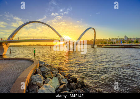 Scenic and iconic Elizabeth Quay Bridge at sunset light on Swan River at entrance of Elizabeth Quay marina. The arched pedestrian bridge is a new tourist attraction in Perth, Western Australia. Stock Photo