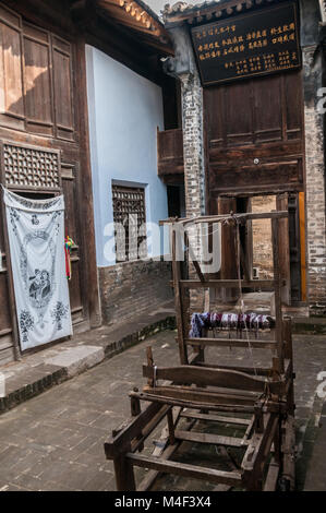 An old wooden loom in the courtyard of a building in the Ming Dynasty village of Dangjiacun near Hancheng, Shaanxi Province, China. Stock Photo