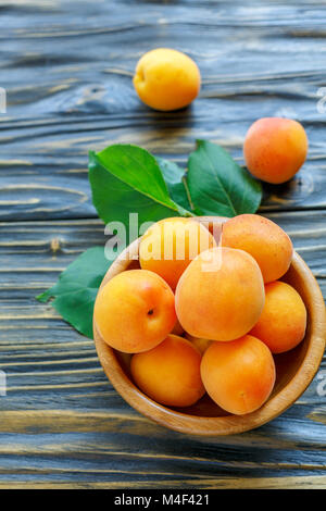 Ripe apricots in a wooden bowl. Stock Photo