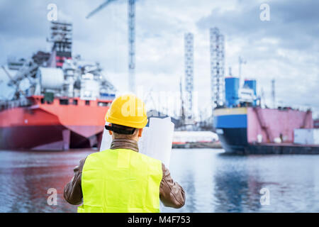 Shipbuilding engineer checking documents at the dockside in a port. Stock Photo