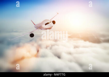 Passenger airplane flying at sunset, blue sky. Stock Photo
