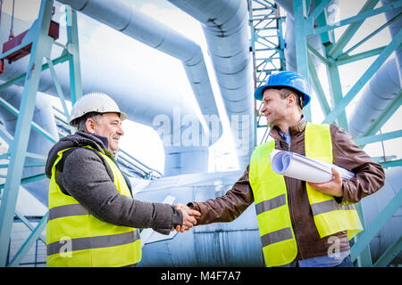 Oil refinery engineers successful deal handshake. Stock Photo