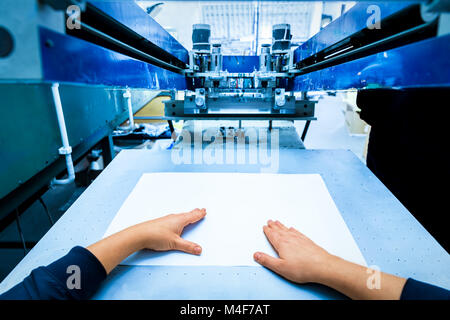 Worker setting print screening metal machine Stock Photo