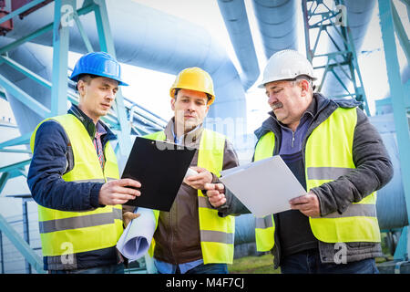 Engineers discussing maintenance of a petrochemical plant Stock Photo