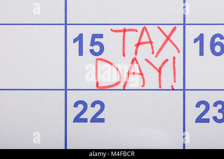 Close-up Of Tax Day Written On Calendar Date Stock Photo