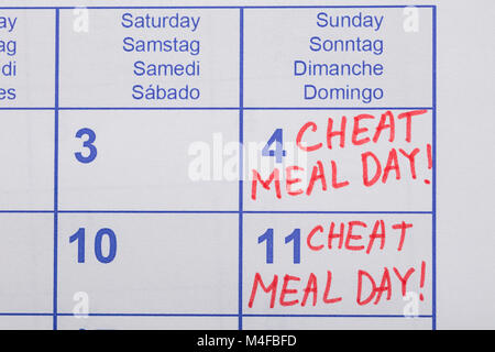 Close-up Of Cheat Meal Day Text Written On Calendar Date Stock Photo