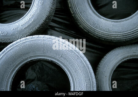 Old heap of tires , tyres outside with frost on them Stock Photo