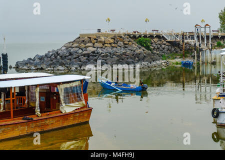 EIN GEV, ISRAEL - FEBRUARY 11, 2018: Scene of the pier of kibbutz Ein Gev, on the eastern shore of the Sea of Galilee, with local fishermen. In Northe Stock Photo