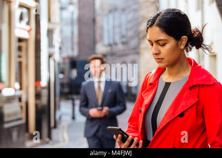 Businesspeople using smart phones in the city. Stock Photo