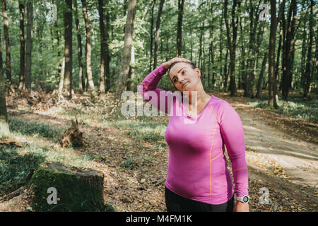 Portrait of a curvy female jogger warming up before a morning jog. Stock Photo