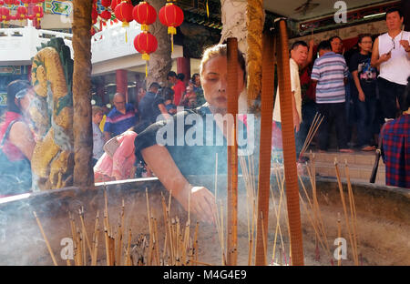 Kuala Lumpur, Malaysia - February 16, 2018: Woman burn incense sticks and pray for good fortune during Chinese New Year Day in Thean Hou Temple. Credit: Nokuro/Alamy Live News Stock Photo