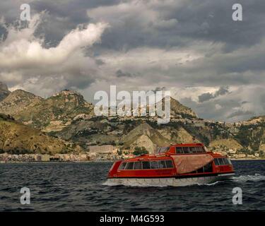 Giardini Naxos, Sicily, Italy. 12th Oct, 2004. A cruise ship passenger tender heads for the resort town of Giardini Naxos, on the east coast of Sicily. Taormina town sits above it atop the rocky peninsula overlooking Naxos Bay and the Ionian Sea, a popular tourist destination. Credit: Arnold Drapkin/ZUMA Wire/Alamy Live News Stock Photo