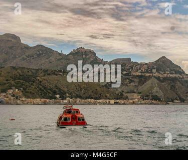 Giardini Naxos, Sicily, Italy. 12th Oct, 2004. A cruise ship passenger tender heads for the resort town of Giardini Naxos, on the east coast of Sicily. Taormina town sits above it atop the rocky peninsula overlooking Naxos Bay and the Ionian Sea, a popular tourist destination. Credit: Arnold Drapkin/ZUMA Wire/Alamy Live News Stock Photo