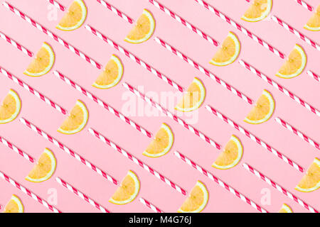 Pattern of lemon slices and straws  on light pink background. Funny lemonade concept Stock Photo