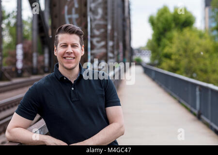 Portrait of a man posing on a city bridge. Medium shot. Stock Photo