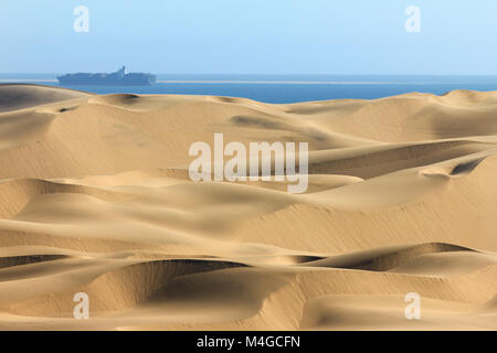 Big sand dunes. Ocean with ships and boat in background. Stock Photo