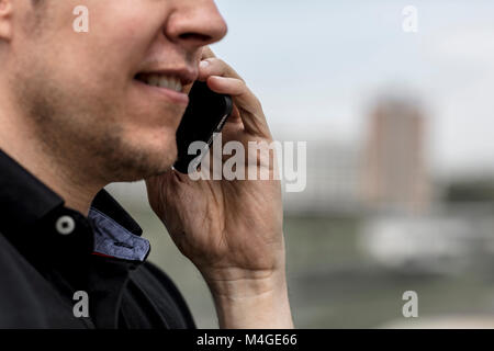 A man's lower face while talking on a cell phone. Close up. Stock Photo