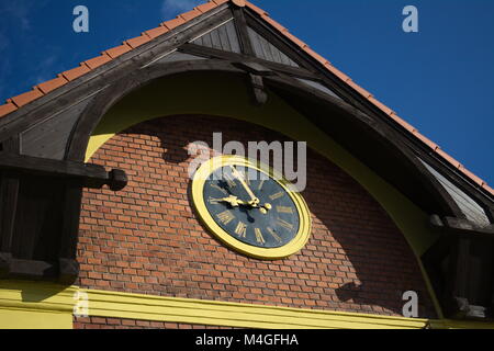 Black tower clock on a brick wall Stock Photo