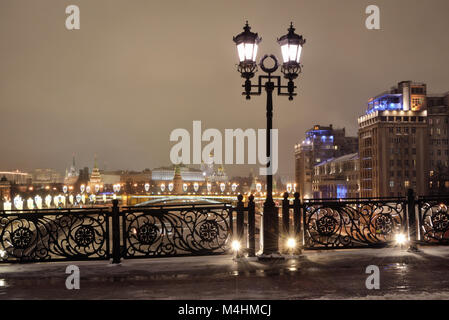 View of the Moscow Kremlin and Estrada Theater from the Patriarchal Bridge and an openwork fence on a winter evening. Stock Photo