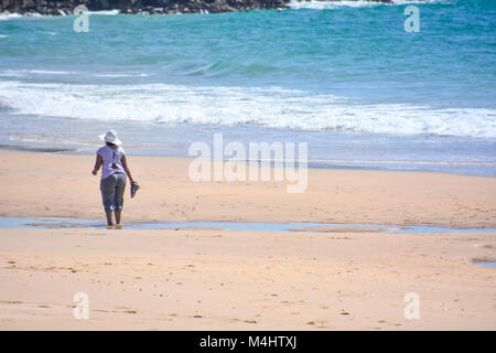 A female subject walking on the beach of Robberg near Plettenberg Bay in South Africa with Indian Ocean in the background Stock Photo
