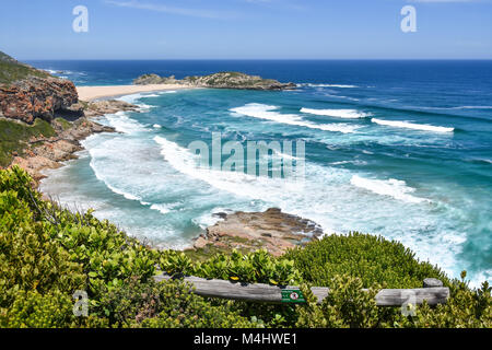 An view of the coastline and the beach of Robberg near Plettenberg Bay in South Africa with waves in the Indian Ocean and a blue sky Stock Photo