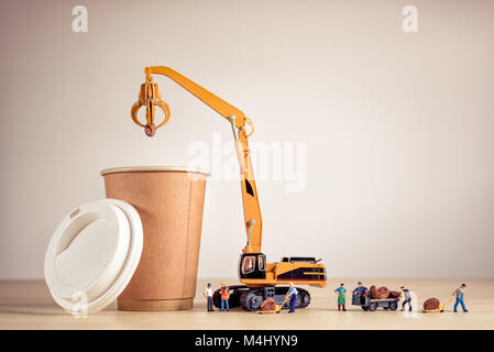 Miniature baristas making coffee in a to-go coffee cup. Stock Photo
