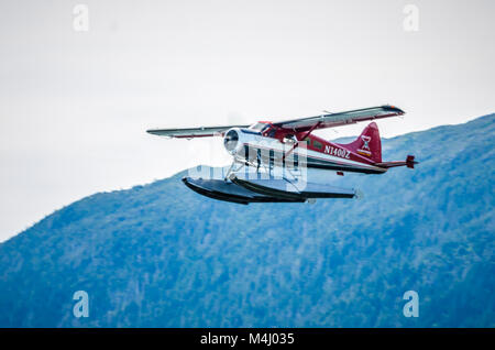 Single Prop Airplane Pontoon Plane flying in alaska mountains Stock Photo