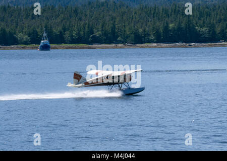 Single Prop Airplane Pontoon Plane flying in alaska mountains Stock Photo