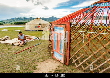 Khutag Ondor, Central Mongolia - July 17, 2010: Nomad constructs a yurt, called a ger, on Central Mongolian steppe near Khutag Ondor village Stock Photo