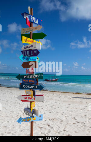 Playa del Carmen, Mexico - February 5, 2018: Funny direction signpost with distance to many different countries on Mexican coastline. This resort area Stock Photo