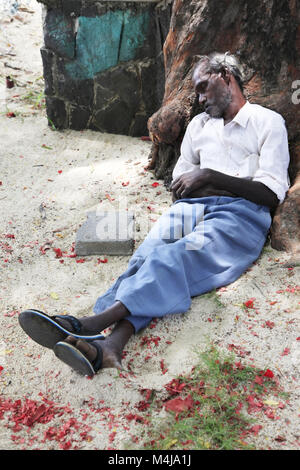 homeless man sleeps on the sidewalk in city Pereber Stock Photo