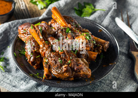 Homemade Braised Lamb Shanks with Sauce and Herbs Stock Photo