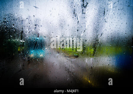 Waterdrops on a glass surface windows with closeup cityscape background. Stock Photo