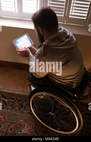 Disabled man using digital tablet Stock Photo