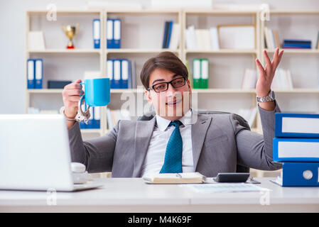 Businessman chained with handcuffs to his coffee Stock Photo