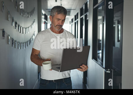Businessman walking with laptop Stock Photo