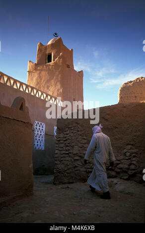Algeria. Taghit or Tarit. Western Sand Sea. Grand Erg Occidental. Sahara desert. Oasis. Man walking in village Mosque. Stock Photo