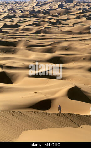 Algeria. Taghit or Tarit. Western Sand Sea. Grand Erg Occidental. Sahara desert. Sand dunes. Sand sea. Tourist, woman walking, hiking. Stock Photo