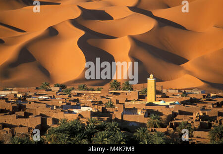 Algeria. Kerzaz. Western Sand Sea. Grand Erg Occidental. Sahara desert. Panoramic view of oasis, village, Mosque and dunes, sand sea and palm trees. Stock Photo