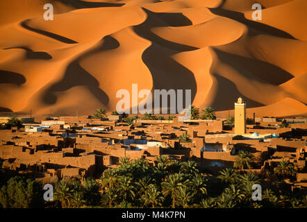 Algeria. Kerzaz. Western Sand Sea. Grand Erg Occidental. Sahara desert. Panoramic view of oasis, village, Mosque and dunes, sand sea and palm trees. Stock Photo