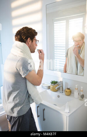 Man brushing his teeth in bathroom Stock Photo